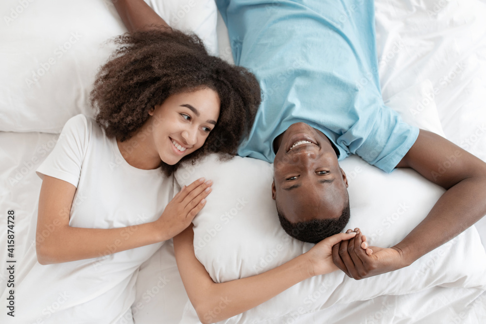 Young family lying in bed together, romantic couple of lovers are looking at each other