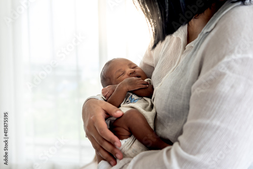 Obraz na plátně Portrait images of half African half Thai, 12-day-old baby newborn son, sleeping with his mother being held, to family and infant newborn concept