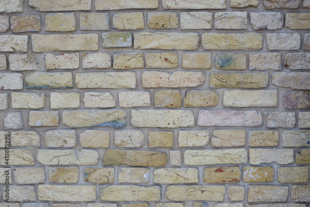 Fototapeta premium Peeled old brick wall. Brick yellow background.