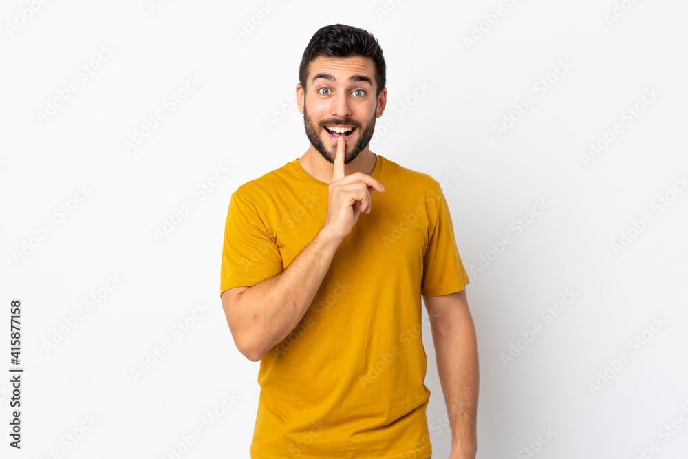 Young handsome man with beard isolated on white background showing a sign of silence gesture putting finger in mouth Young handsome man with beard isolated on white background showing a sign of silence gesture putting finger in mouth
