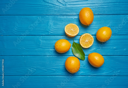 Fresh ripe lemons on blue wooden table. Top view with copy space.