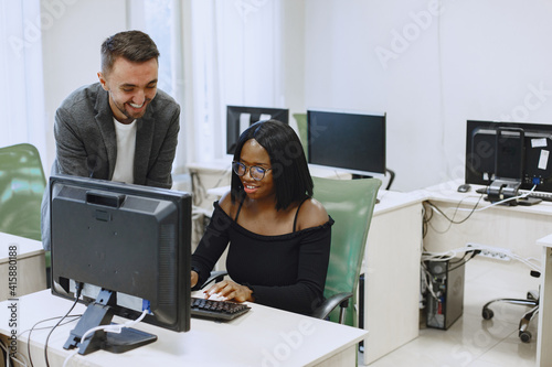 African woman with friend. Man and woman communicate. Students study computer science.