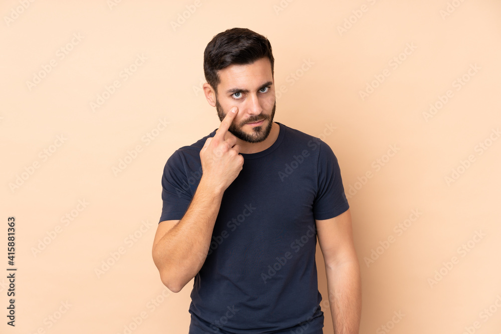 Caucasian handsome man isolated on beige background showing something Caucasian handsome man isolated on beige background showing something