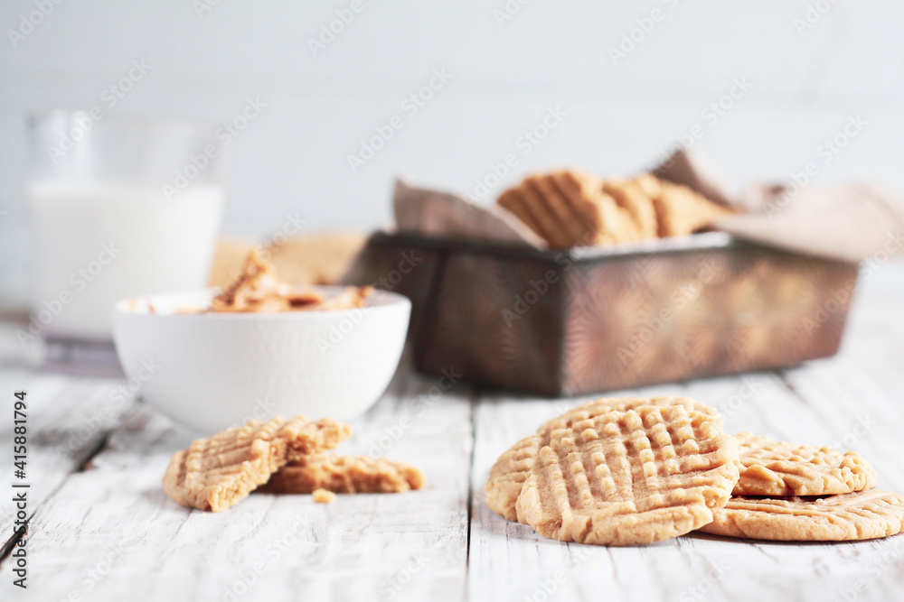 Fresh baked, homemade peanut butter cookies and milk over a white rustic table. Selective focus with blurred background. Fresh baked, homemade peanut butter cookies and milk over a white rustic table. Selective focus with blurred background.