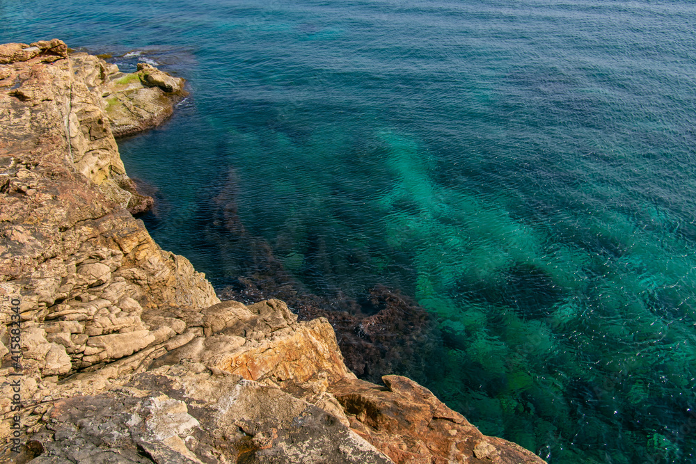 Sliema rocky beach in Malta. Beautiful blue mediterranean sea. Selective focus. 