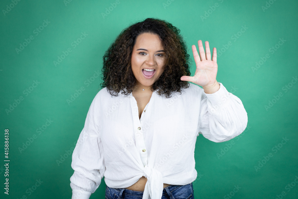 Young african american girl wearing white shirt over green background showing and pointing up with fingers number five while smiling confident and happy Young african american girl wearing white shirt over green background showing and pointing up with fingers number five while smiling confident and happy