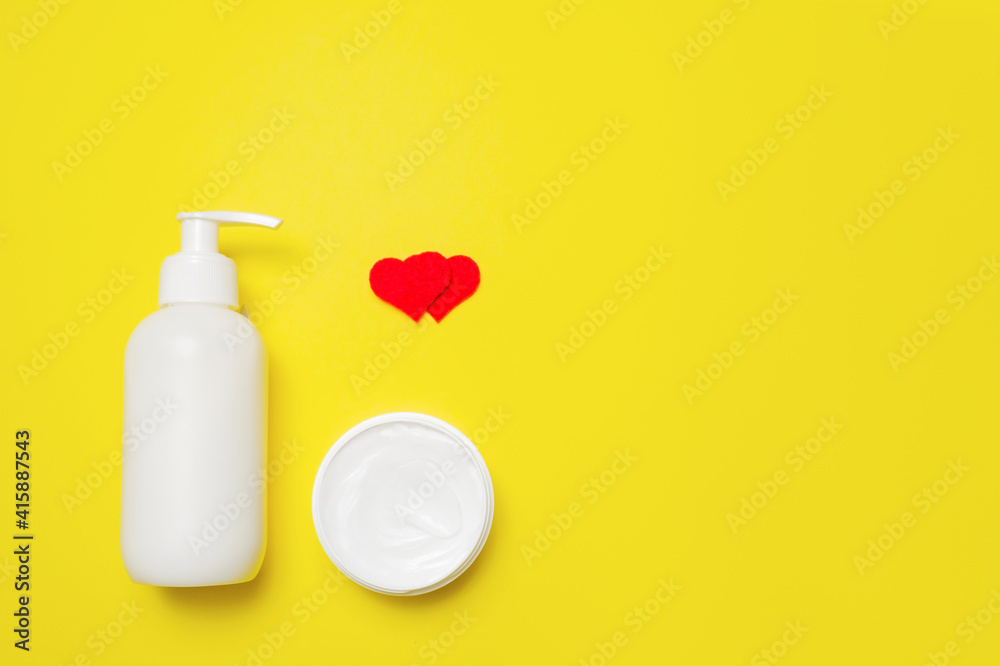 Cream in a bottle and jar with hearts on a yellow background. Cream in a bottle and jar with hearts on a yellow background.