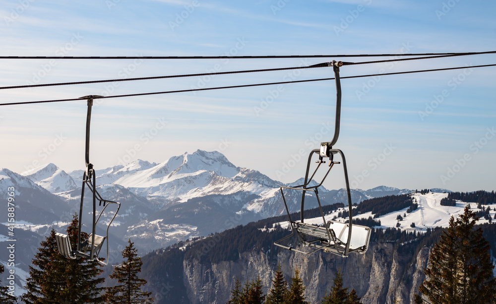 view on a snow-capped summit framed by chairlifts on a sunny day