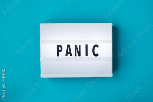 Lightbox with a words text Panic board on blue background. Concept panic mood during quarantine period, pandemic of coronavirus.