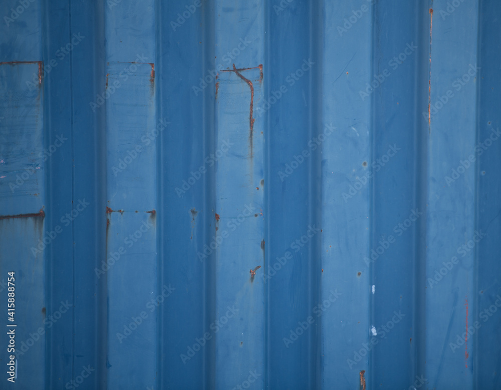 Blue grungy corrugated metal wall of industrial container rusty and old for metallic background striped with vertical lines g=horizontal format
