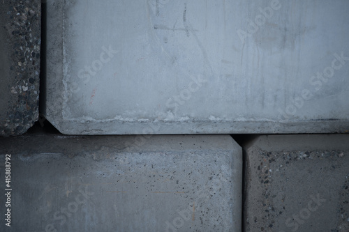concrete cement wall of large cement blocks stacked up as exterior wall of building on construction site weathered hard surface in shades of grey stacked together horizontal format