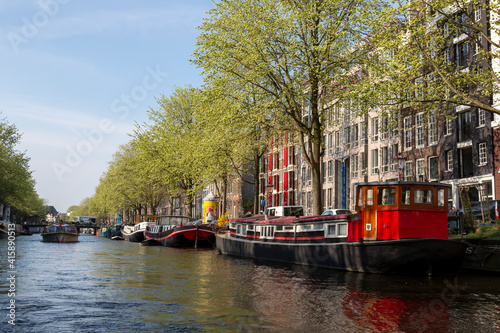 Europe, Netherlands, Amsterdam. Canal tour boat and cityscape.