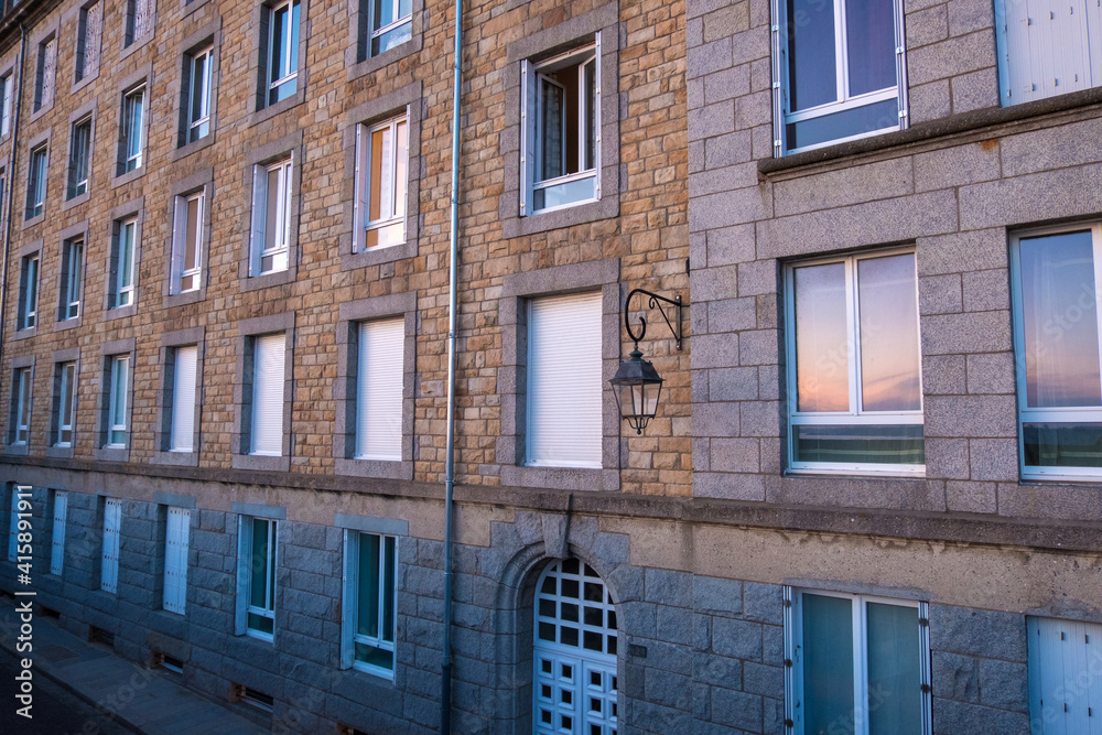 Naklejka premium View at sunset from the wall of the old city with granite buildings of Saint-Malo in Brittany, France