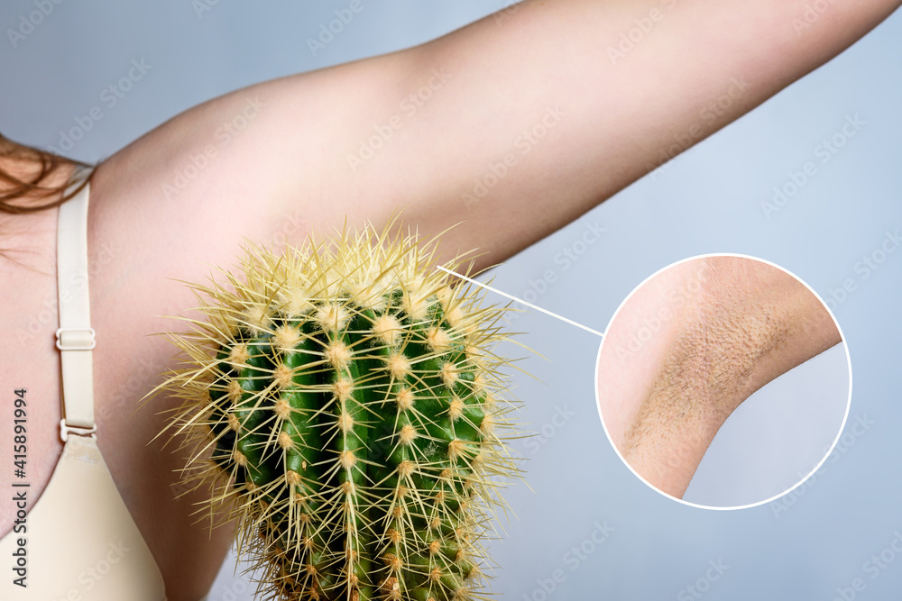 Young woman holding cactus near underarm on gray background. Hair