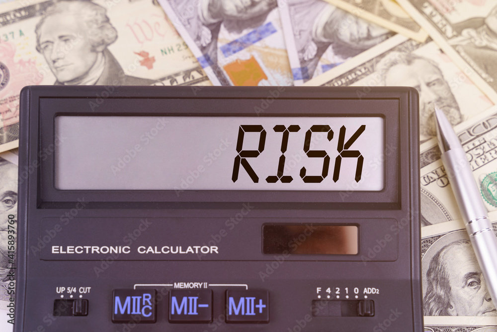 On the table are dollars and a calculator on the electronic board which says RISK