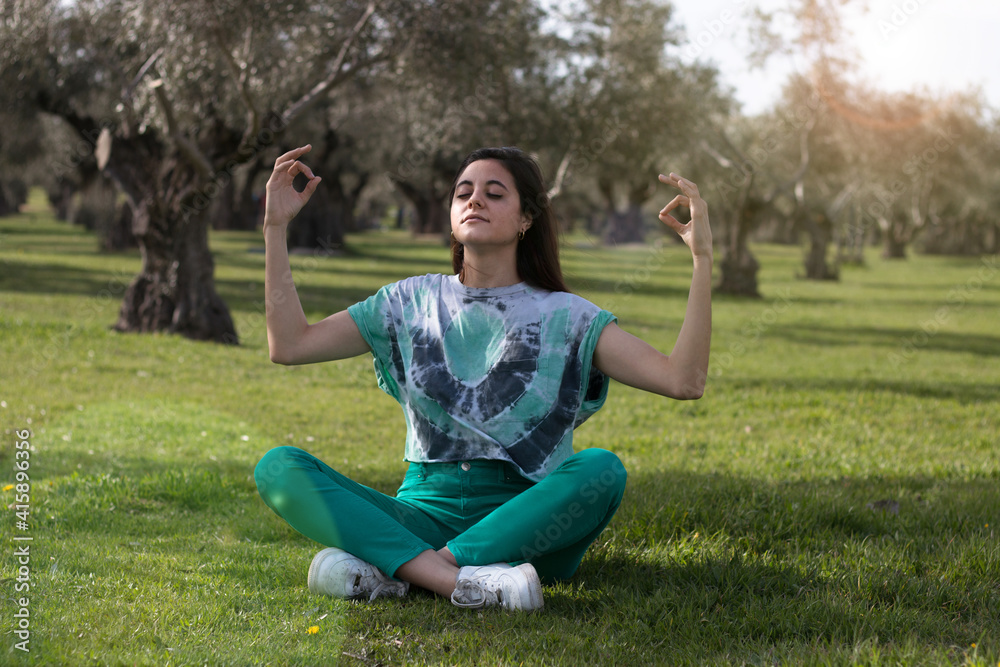 Woman meditating in the park wearing colorful clothes Woman meditating in the park wearing colorful clothes