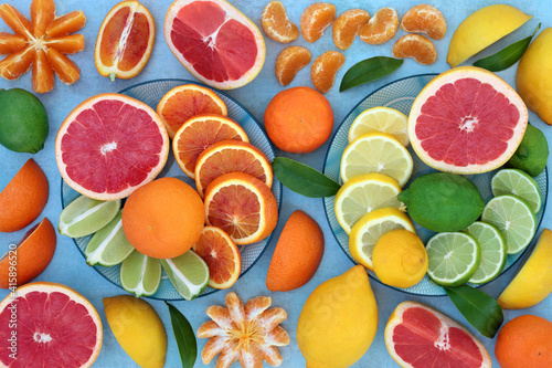 Fresh citrus fruit with oranges, lemons, mandarins, limes & grapefruit high in antioxidants, anthocyanins, lycopene, fibre & vitamin c. Healthy immune boosting concept. On mottled blue.