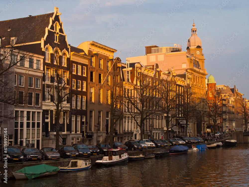 Netherlands, Amsterdam. Clock tower on historic building along the canal.