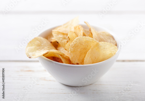Potato chips on bowl on white background