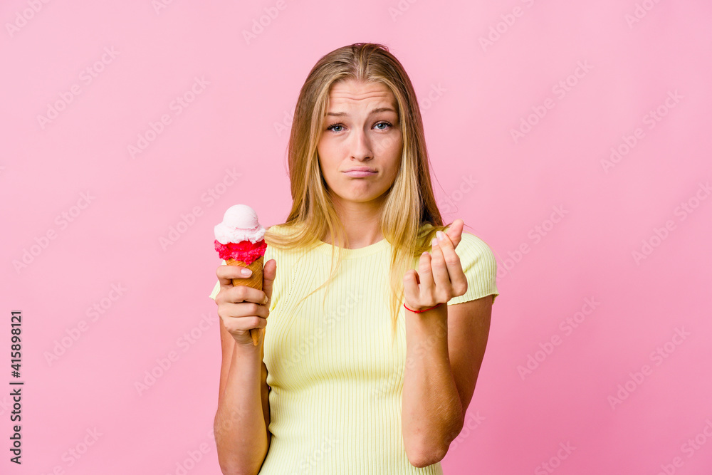 Young russian woman eating an ice cream isolated showing that she has no money. Young russian woman eating an ice cream isolated showing that she has no money.