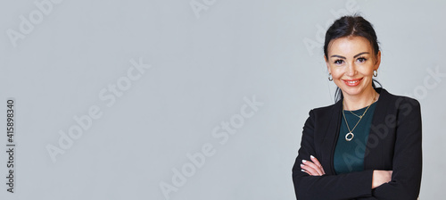 Portrait of a confident smiling senior business woman with arms folded. Horizontal banner. Copyspace.