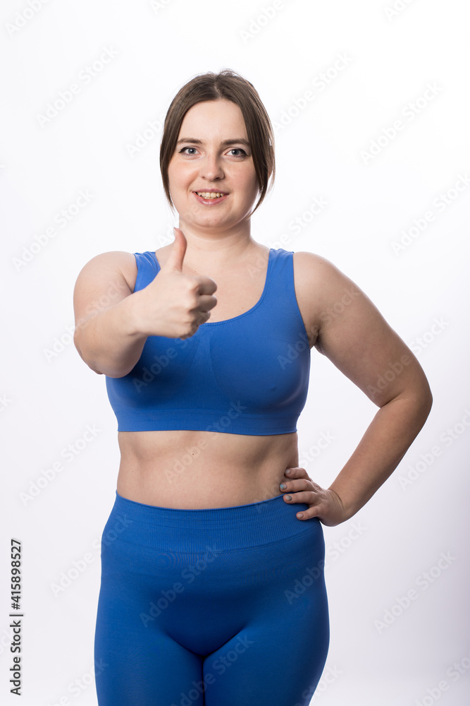 Young plus size woman in sports uniform shows 