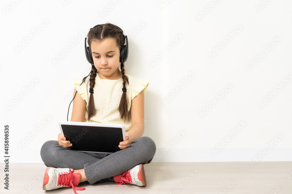 sitting little girl with tablet and headphones sitting little girl with tablet and headphones