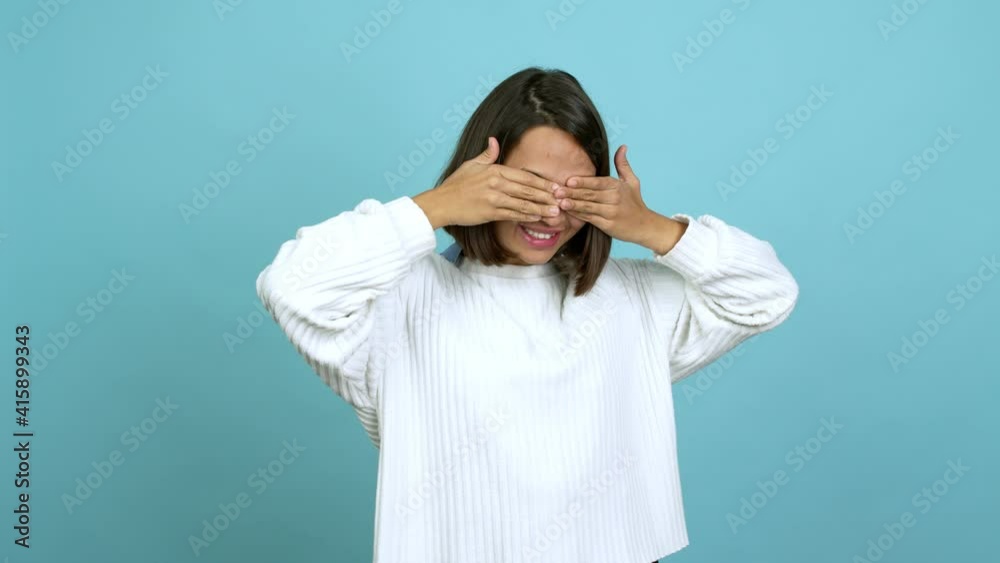 Young brunette woman covering eyes by hands. Surprised to see what is ahead over isolated background Young brunette woman covering eyes by hands. Surprised to see what is ahead over isolated background