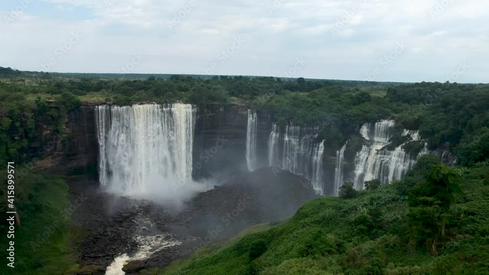 Distant view of Calandula waterfalls in Angola swallows flying around the camera mist all around the waterfall Aerial Distant view of Calandula waterfalls in Angola swallows flying around the camera mist all around the waterfall Aerial
