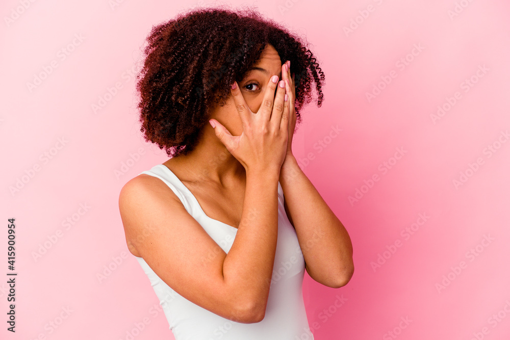 Young african american mixed race woman isolated blink through fingers frightened and nervous. Young african american mixed race woman isolated blink through fingers frightened and nervous.