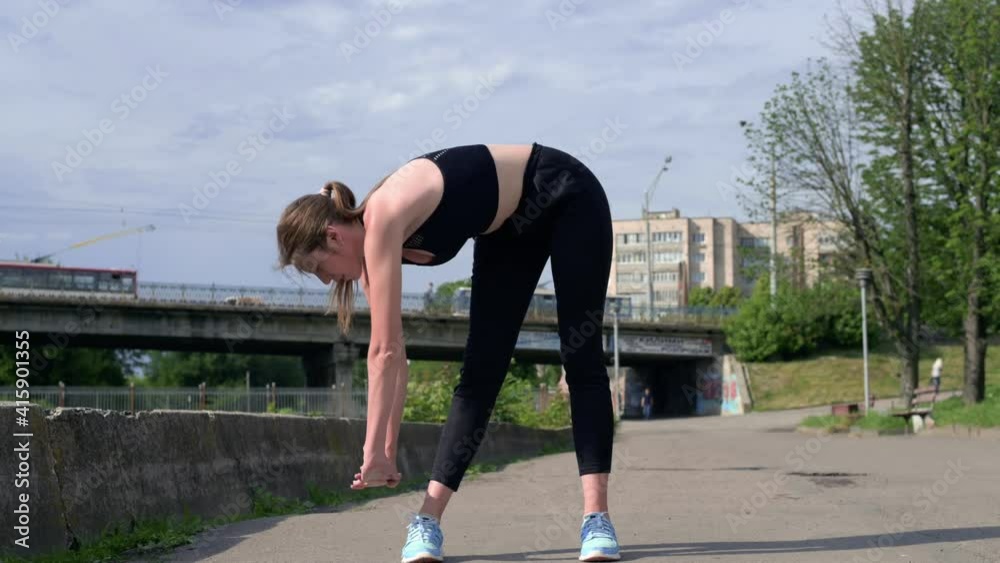 Sporty woman doing sports physical exercises on the city street. Caucasian young adult female training outdoor. Fitness, sport and healthy lifestyle concept Sporty woman doing sports physical exercises on the city street. Caucasian young adult female training outdoor. Fitness, sport and healthy lifestyle concept