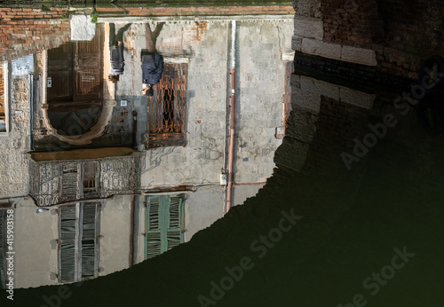 Reflection of people in the water under the bridge