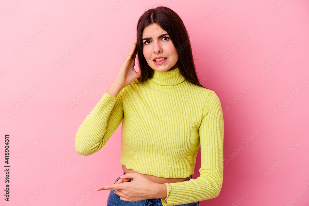 Young caucasian woman isolated on pink background trying to listening a gossip. Young caucasian woman isolated on pink background trying to listening a gossip.