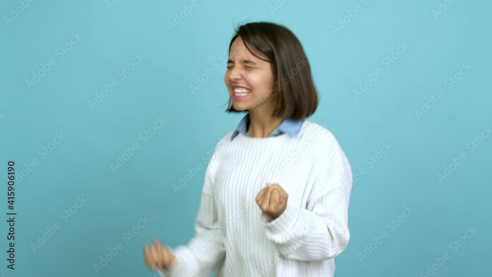 Young brunette woman celebrating a victory over isolated background Young brunette woman celebrating a victory over isolated background