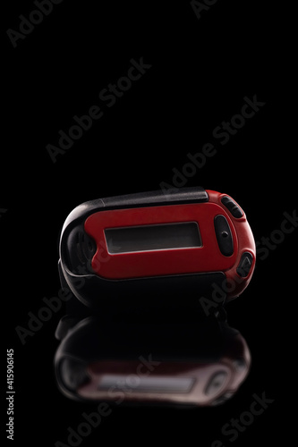 Retro red pager captured isolated on black background and reflective surface photo