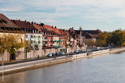 Wuerzburg, Germany, view of the Main river, modern typical German houses are standing along, people stroll along the embankment photo