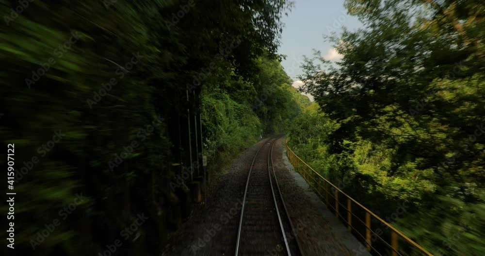 View from a train journey, on the small Japanese line to Kasagi, lush river valley scenery, single track railway line View from a train journey, on the small Japanese line to Kasagi, lush river valley scenery, single track railway line