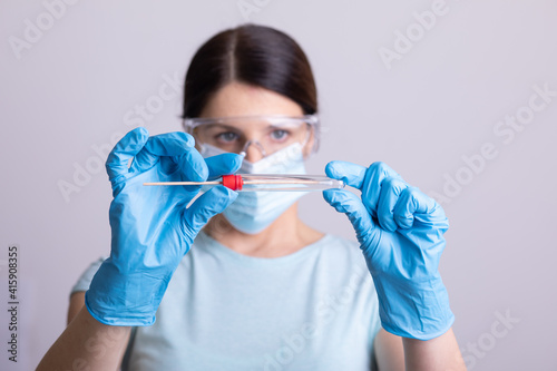 Doctor holding test kit for PCR testing virus covid19. Coronavirus COVID-19 swab test kit  PPE protective mask and gloves  tube for taking OP NP patient specimen sample  DNA RNA protocol process