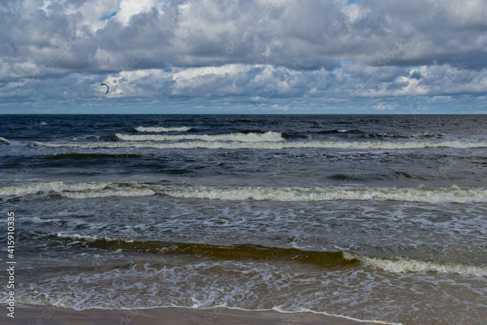 Beach during the day. Clouds and sea waves.