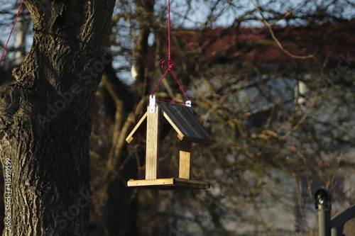 drewniany  karmnik  dla  ptaków  zawieszony  na  drzewie