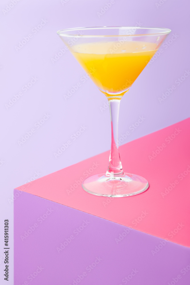 Glass of cocktail with lemon on colorful table Glass of cocktail with lemon on colorful table