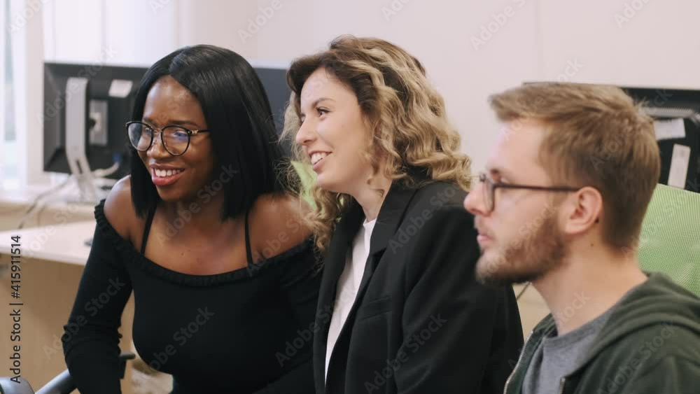 Diverse office team gather talk laugh work together with a computer. Diverse office team gather talk laugh work together with a computer.