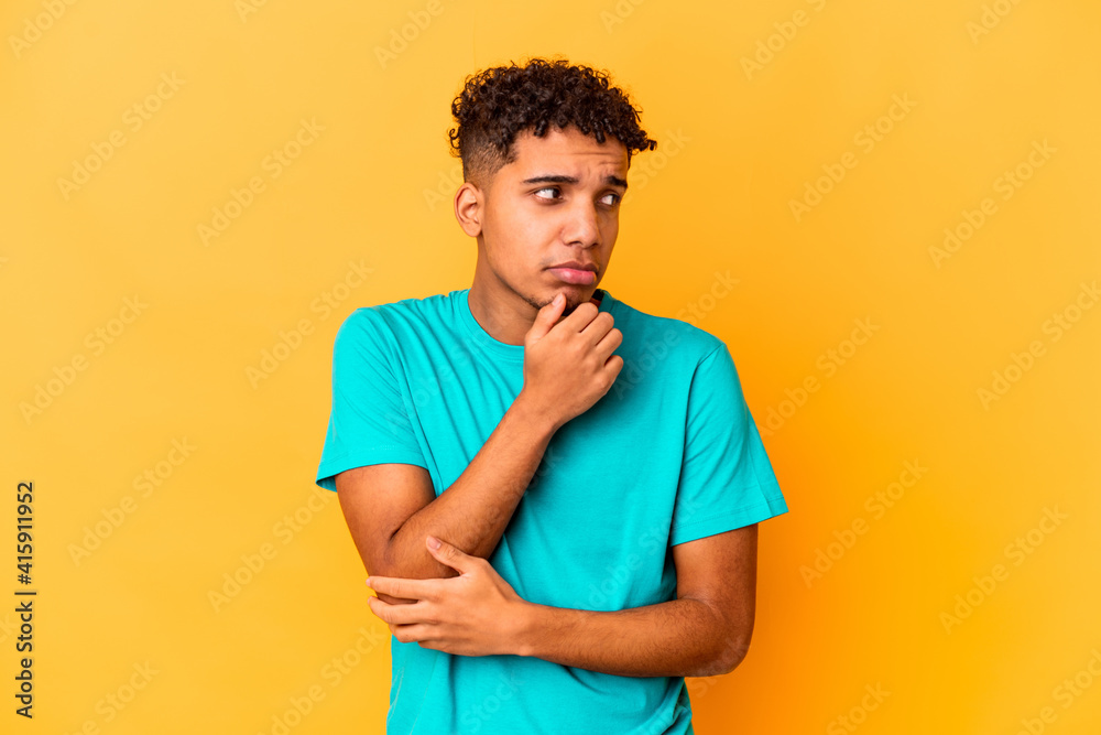 Young african american curly man isolated on purple confused, feels doubtful and unsure. Young african american curly man isolated on purple confused, feels doubtful and unsure.