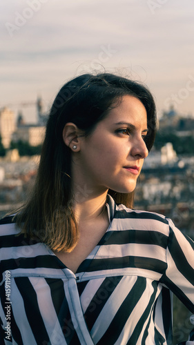 Joven mujer posando con camisa de rayas al atardecer photo