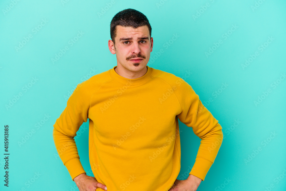 Young caucasian man isolated on blue background sad, serious face, feeling miserable and displeased. Young caucasian man isolated on blue background sad, serious face, feeling miserable and displeased.