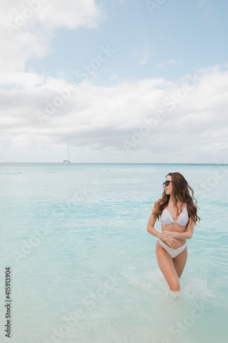 Relaxed woman enjoying sun, freedom and life an beautiful beach in sunset. Young lady feeling free, relaxed and happy. Concept of vacations, freedom, happiness, enjoyment and well being. © ALEXSTUDIO