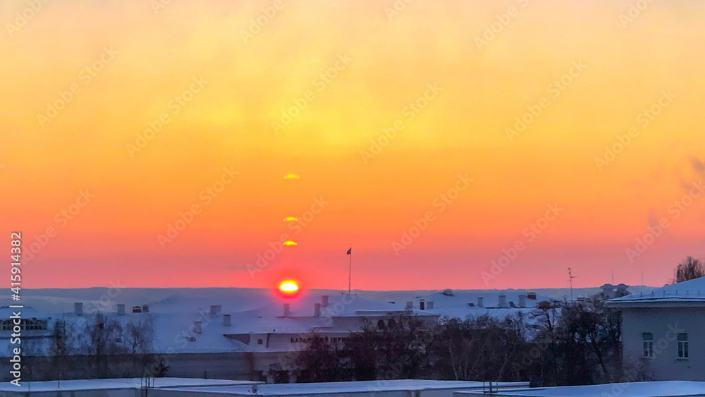 The sunset over the city and hills with orange sky. 