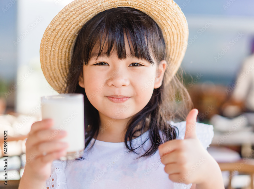 Fresh organic lactose free milk on glass.Asian cute little girl