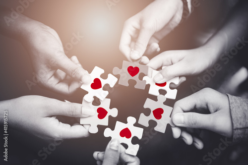 CSR (coporate social responsibility) or teamwork.Top view of business people putting jigsaw with heart for team together.Charity, volunteer.Donate, blood, family team business.Heart day awareness.