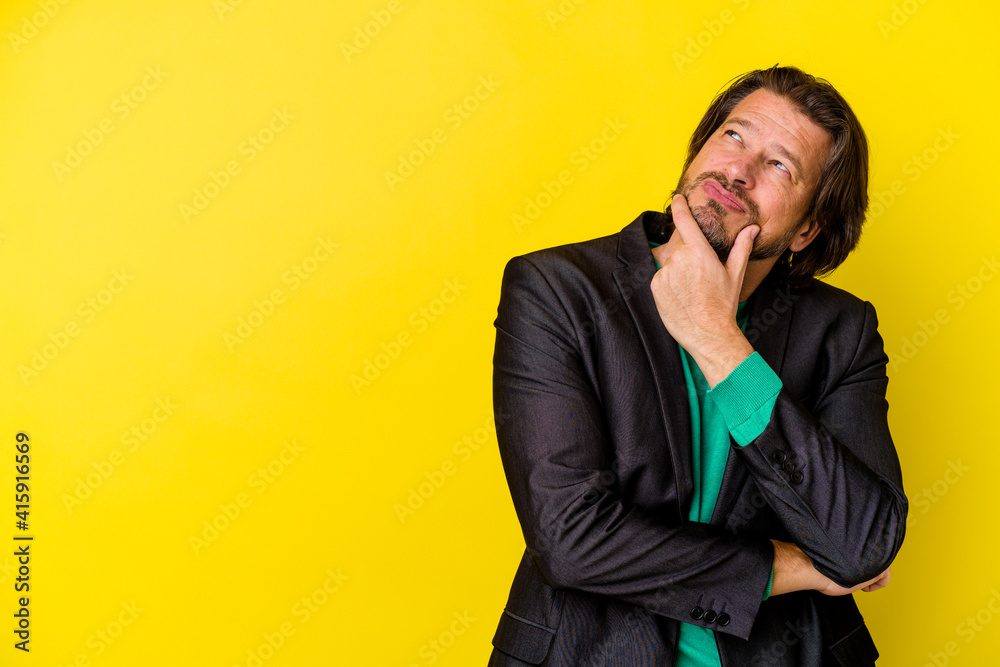 Middle age caucasian man isolated on yellow background looking sideways with doubtful and skeptical expression. Middle age caucasian man isolated on yellow background looking sideways with doubtful and skeptical expression.